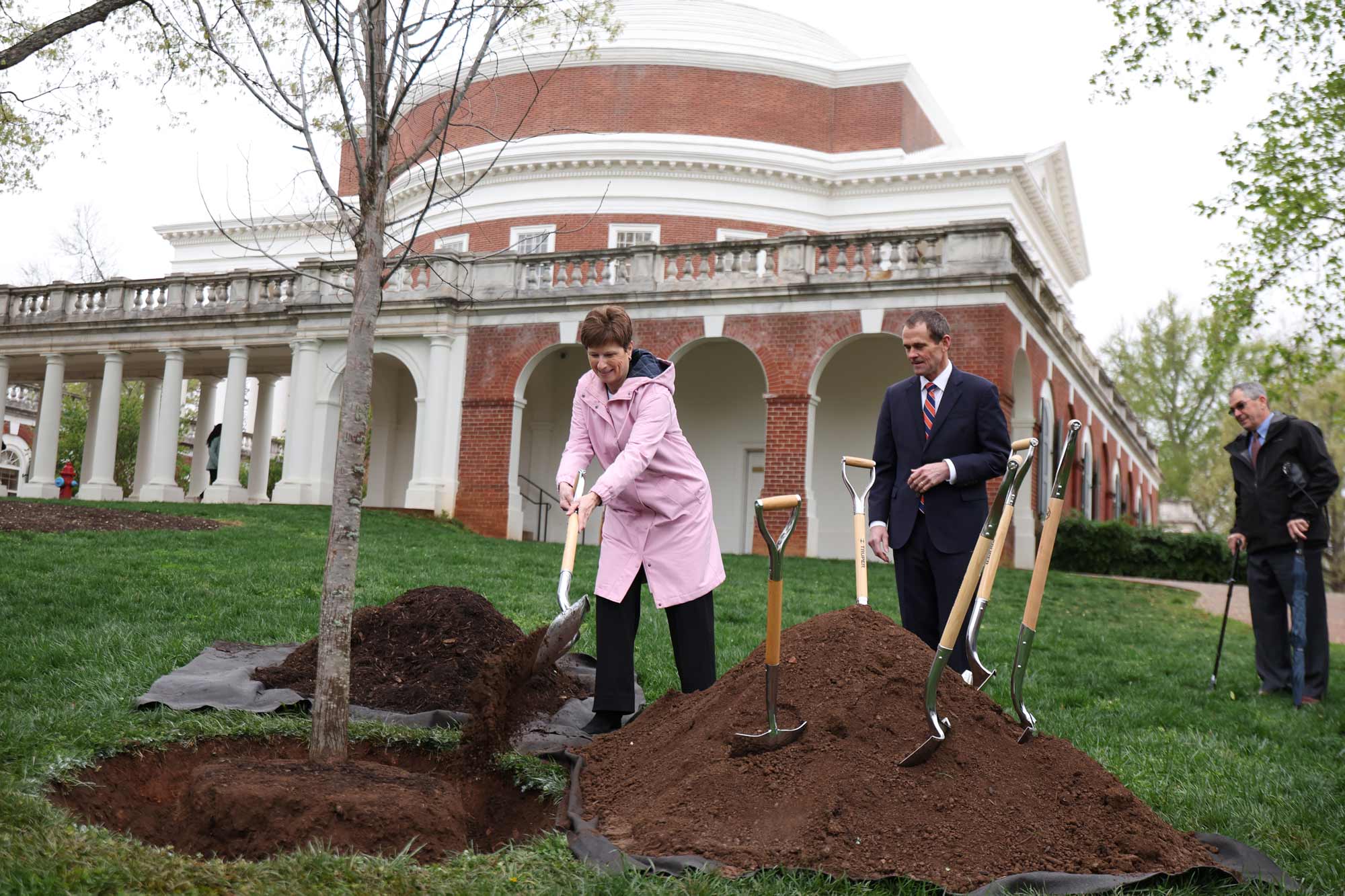 Colette Sheehy and President Jim Ryan shoveling dirt onto a planted tree