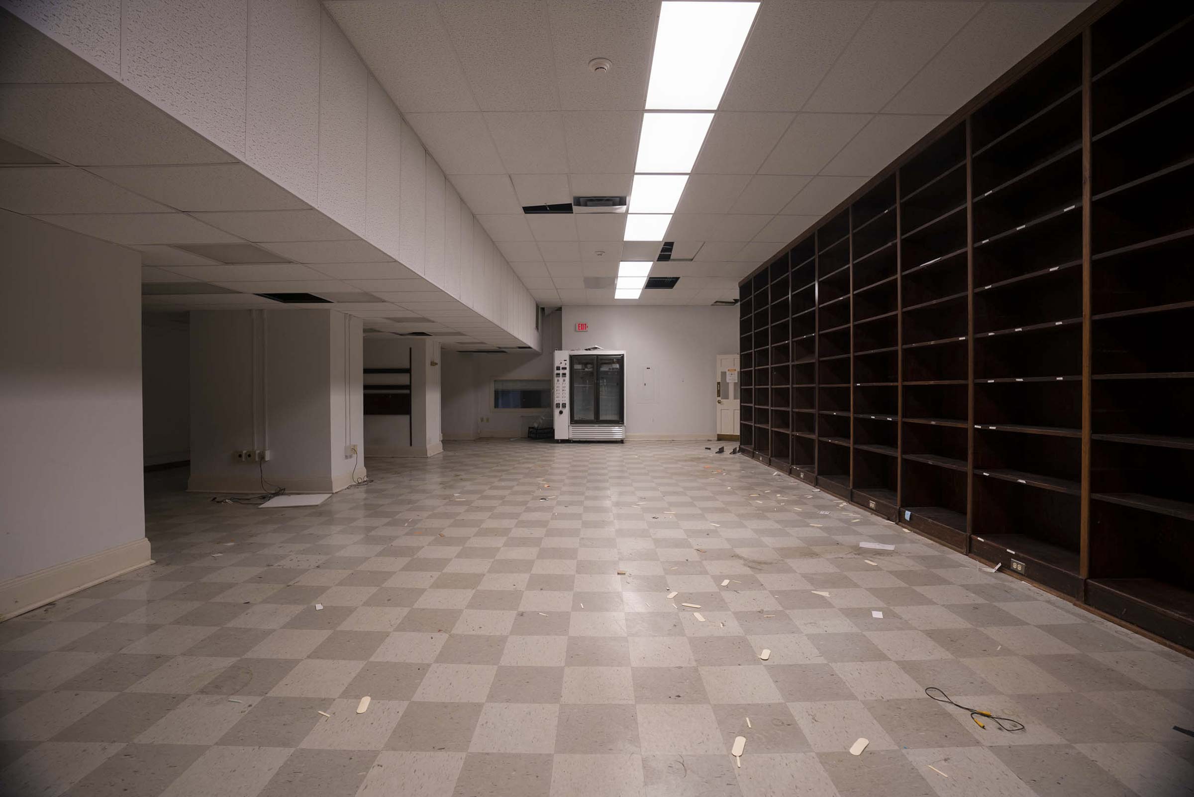 Empty room with dark wooden shelves on the right that goes from the floor to ceiling